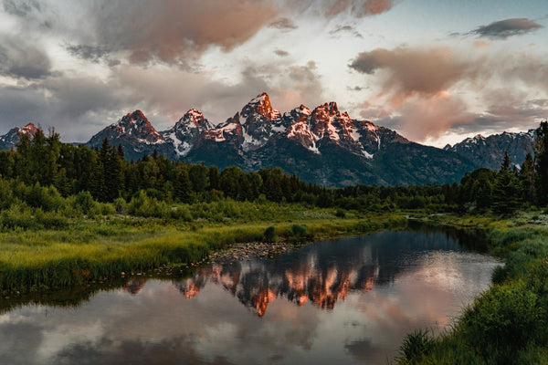 Sunrise alpenglow on the Teton Range reflected in a lake, Grand Teton National Park, Wyoming